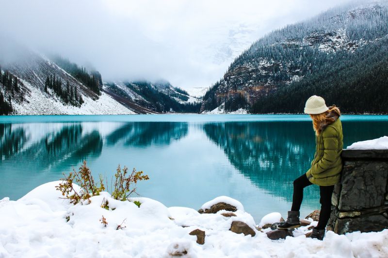 Woman wearing an insulated jacket by a lake
