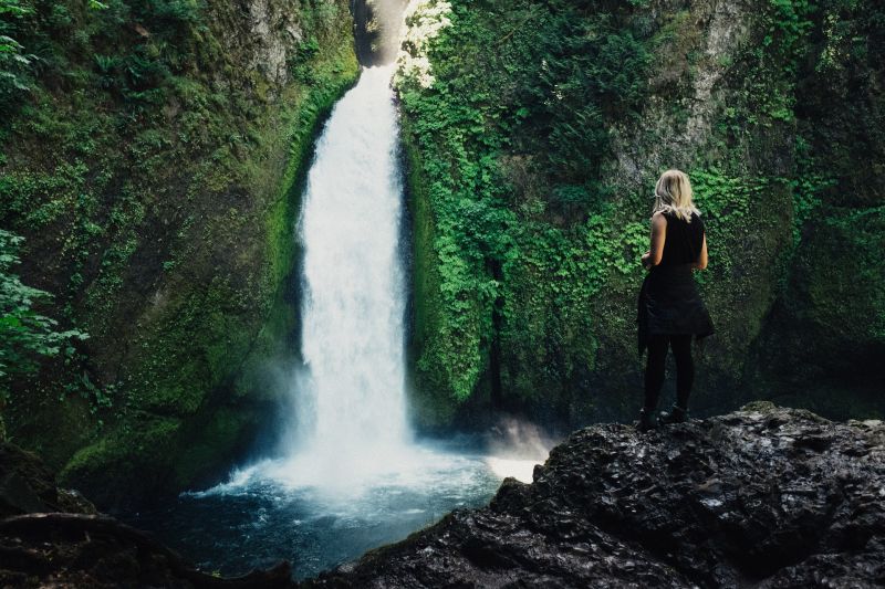 Woman stood by waterfall