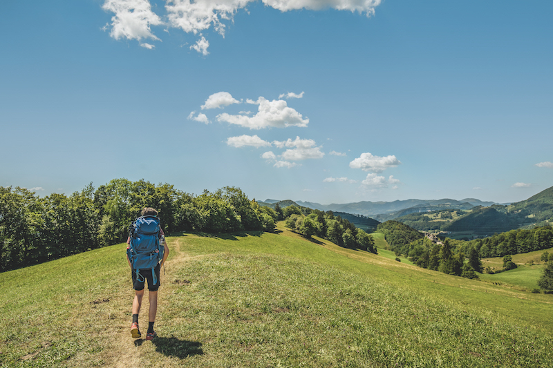 A backpacker admiring he rolling hills of Jura