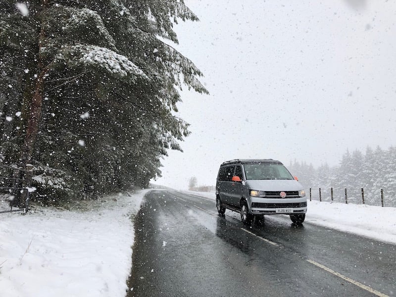 Campervan driving through the snow in Wales