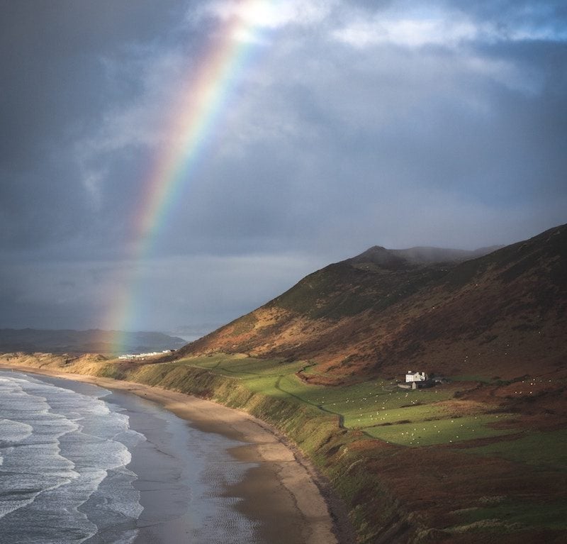 A rainbow over rhossili bay on the gower coast path