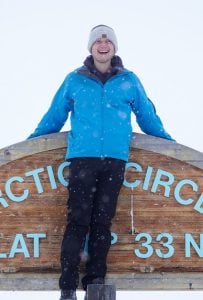 James standing on the Arctic Circle sign