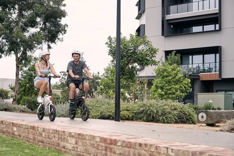 Two people riding DYU D3F E-Bikes through the city