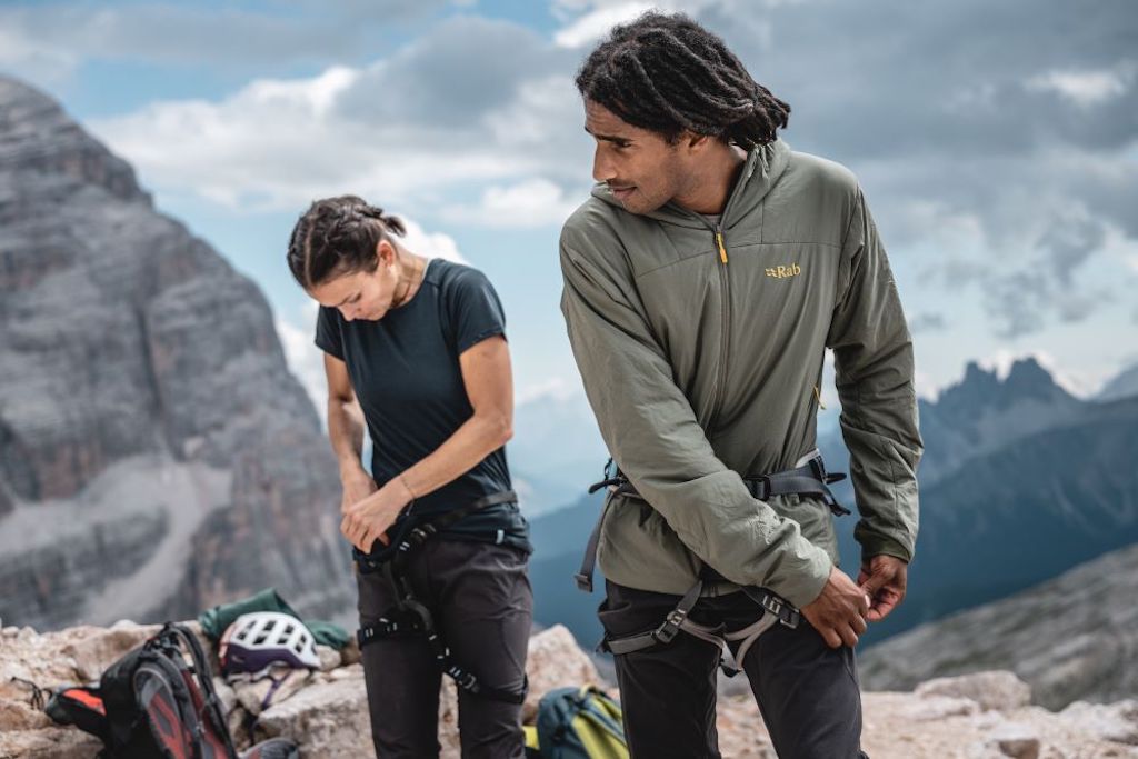 - Male hiker wearing a Rab synthetic insulated jacket in the mountains.